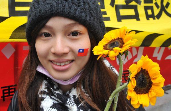 An activist holds sunflowers and displays Taiwan's national flag in support of student protesters occupying the parliament building in Taipei on March 21, 2014. Student protesters occupied Taiwan's parliament to stop the government from ratifying a contentious trade pact with China. (Mandy Cheng/AFP/Getty Images)