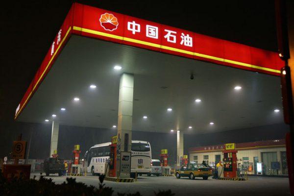 Station attendants serve customers at a PetroChina gas station in Beijing, 05 November 2007. (Frederic J. Brown/AFP/Getty Images)
