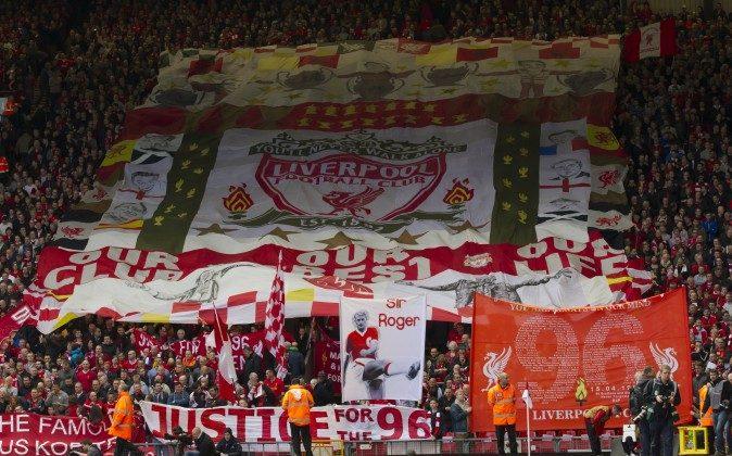 Liverpool supporters hold banners prior to a minute's silence in tribute to the 96 supporters who lost their lives in the Hillsborough disaster of 25 years ago on April 15, 1989, in Liverpool, England, on April 13, 2014. (Jon Super/AP Photo)