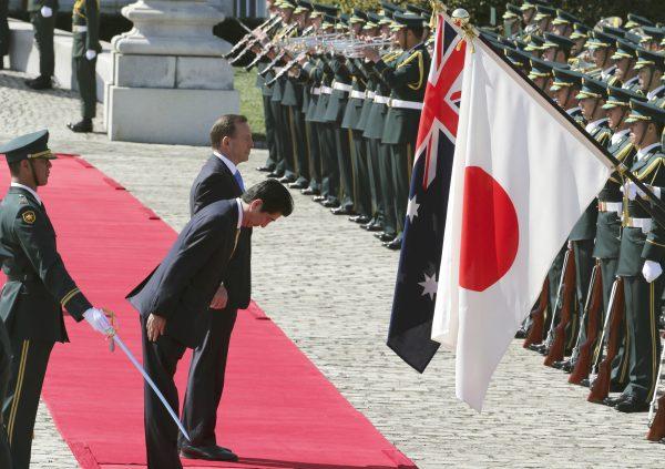 Then Australian Prime Minister Tony Abbott, centre rear, reviews an honour guard during a welcome ceremony with Japanese Prime Minister Shinzo Abe, front, at Akasaka State Guest House in Tokyo Monday, April 7, 2014. (AP Photo/Koji Sasahara)
