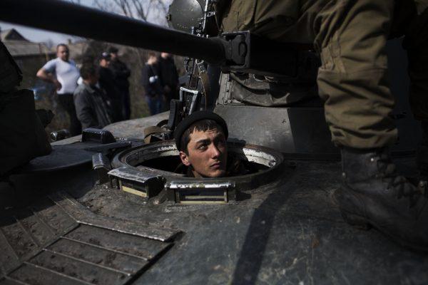 A Ukrainian soldier is seen in a tank of the Ukrainian Army, as their passage is blocked on their way to the town of Kramatorsk on April 16, 2014.  (AP Photo/Manu Brabo)