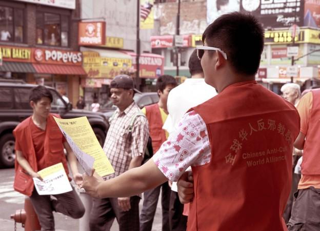 A group of 16-year-old youths try to distribute Chinese Communist Party propaganda in Flushing, New York, on Aug. 10, 2013. (Milene Fernandez/Epoch Times)