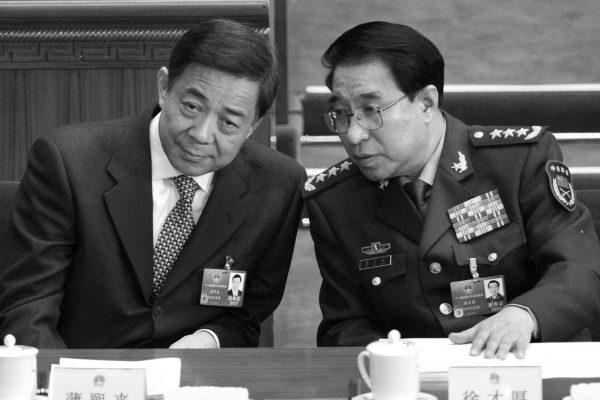Xu Caihou (R), former vice chairman of the Central Military Commission, speaks to Bo Xilai, former Politburo member, during the opening session of the National People's Congress at the Great Hall of the People in Beijing on March 5, 2012. (Liu Jin/AFP/Getty Images)