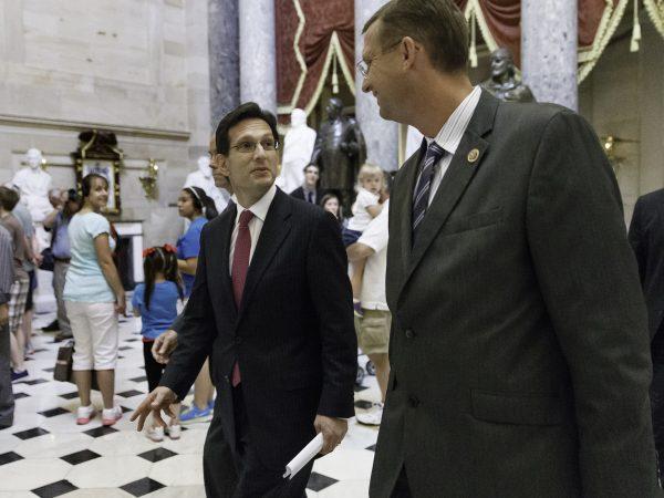 A file photo shows former House Majority Leader Eric Cantor and Rep. Doug Collins, (R-Ga), walking past tourists in Statuary Hall on Capitol Hill in Washington. (J. Scott Applewhite/AP Photo)