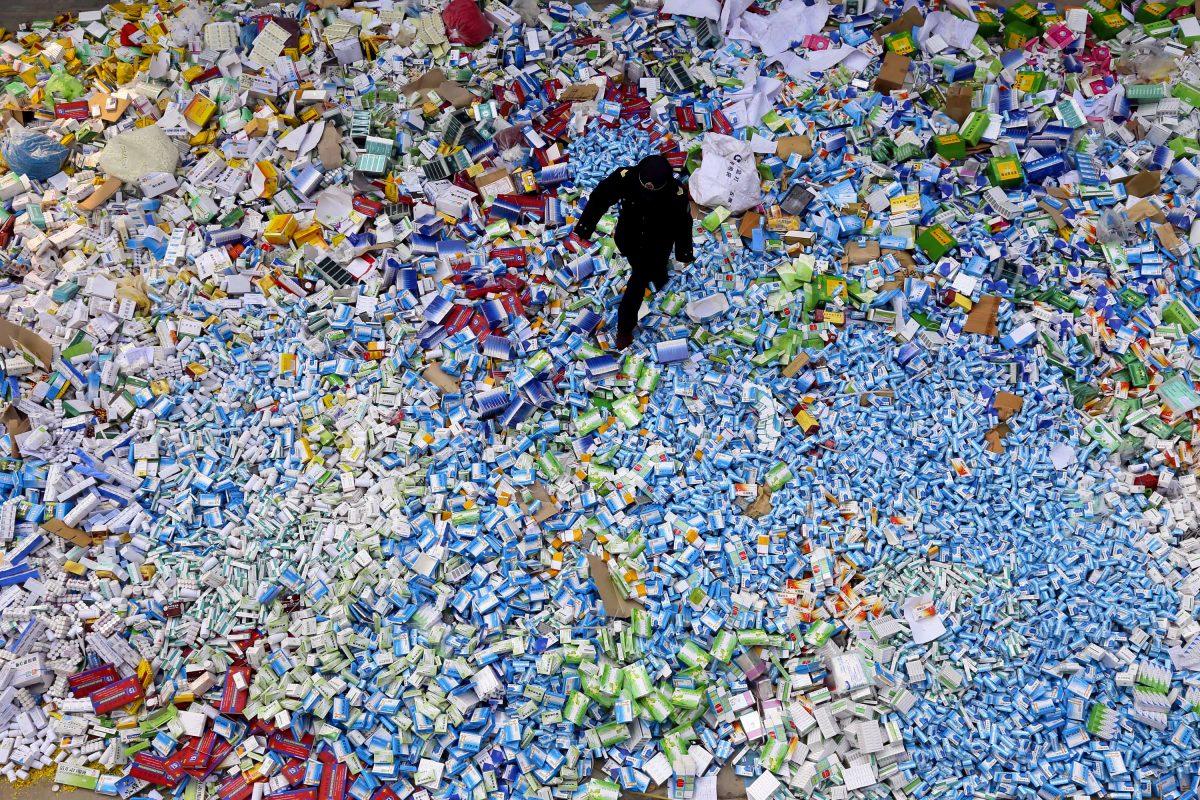 This picture taken on March 14 shows a Chinese policeman walking across a pile of fake medicines seized in Beijing in recent months. The rapid growth of Internet commerce has led to an explosion of counterfeit drugs sold around the world, with China the biggest source of fake medicines, pharmaceutical experts said as the illicit trade is now believed to be worth around 75 billion USD globally, with criminal gangs increasingly using the web to move their products across borders. (STR/AFP/Getty Images)