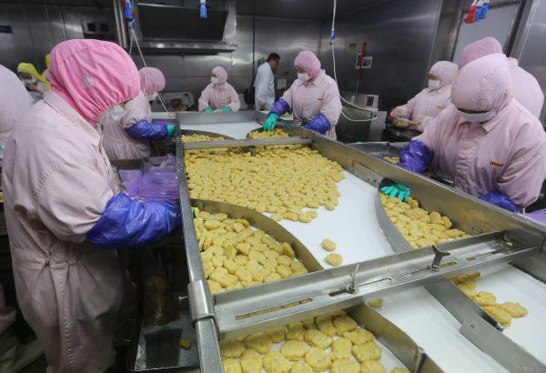 Workers produce food at the Shanghai Husi Food Co., part of the OSI Group, a U.S. food processor, in Shanghai, in this undated photo. Shanghai city officials have shut down the plant for producing fast-food products using expired meat. (STR/AFP/Getty Images)