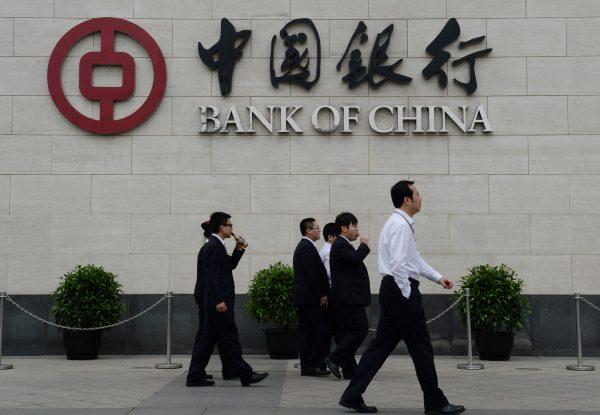 Bank workers walk outside the headquarters of the Bank of China in the Xidan District of Beijing on May 8, 2013. (Mark Ralston/AFP/Getty Images)
