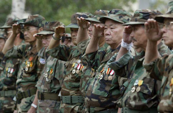 A group of Lao and Hmong veteran soldiers who fought in Vietnam and Loas salute during a ceremony to dedicate a new Lao Hmong American War Memorial at Courthouse Park in downtown Fresno, Calif. Dec. 21, 2005. (AP Photo/The Fresno Bee, Craig Kohrluss, File)