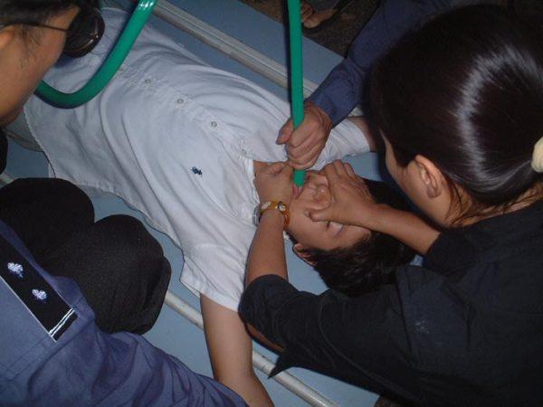  Police officers force-feed a Falun Gong practitioner at the Hongqiao District Detention Center in Tianjin, China, in this file photo. (Courtesy of Minghui.org)