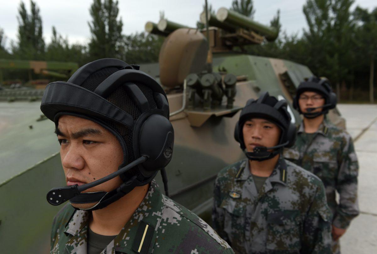 People's Liberation Army cadets wait beside a T-89 Anti-tank Missile Launcher at the PLA's Armored Forces Engineering Academy in Beijing, on July 22, 2014. Xi Jinping, head of the Chinese Communist Party, is calling for a new focus on information warfare. (Greg Baker/AFP/Getty Images)