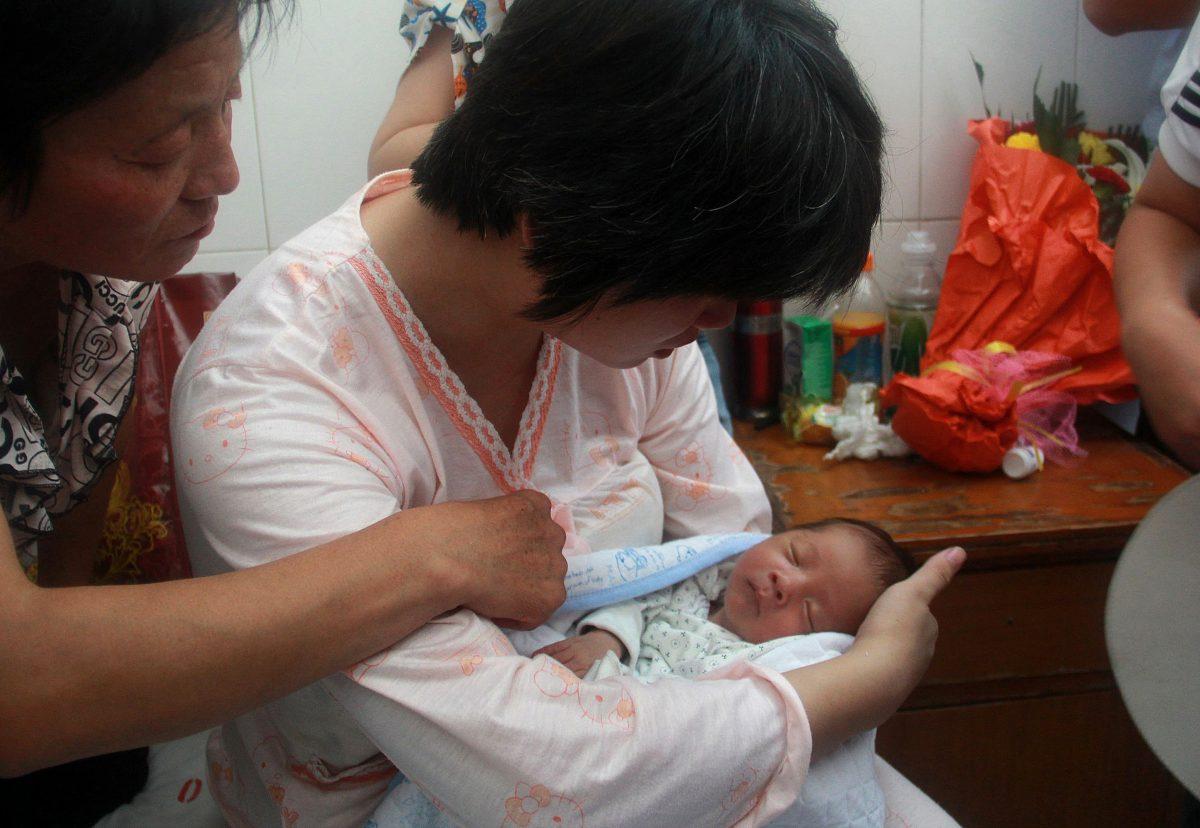 A woman reunites with her newborn baby who was sold by the doctor who delivered him at a hospital in Fuping County, Shanxi Province, China, on Aug. 5, 2013. Other such cases have been reported across China in recent years. (STR/AFP/Getty Images)