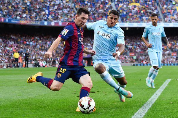 Lionel Messi of FC Barcelona duels for the ball with Juan Carlos Perez of Granda CF during the La Liga match between FC Barcelona and Granada CF at Camp Nou in Barcelona, Spain, on Sept. 27, 2014. (David Ramos/Getty Images)