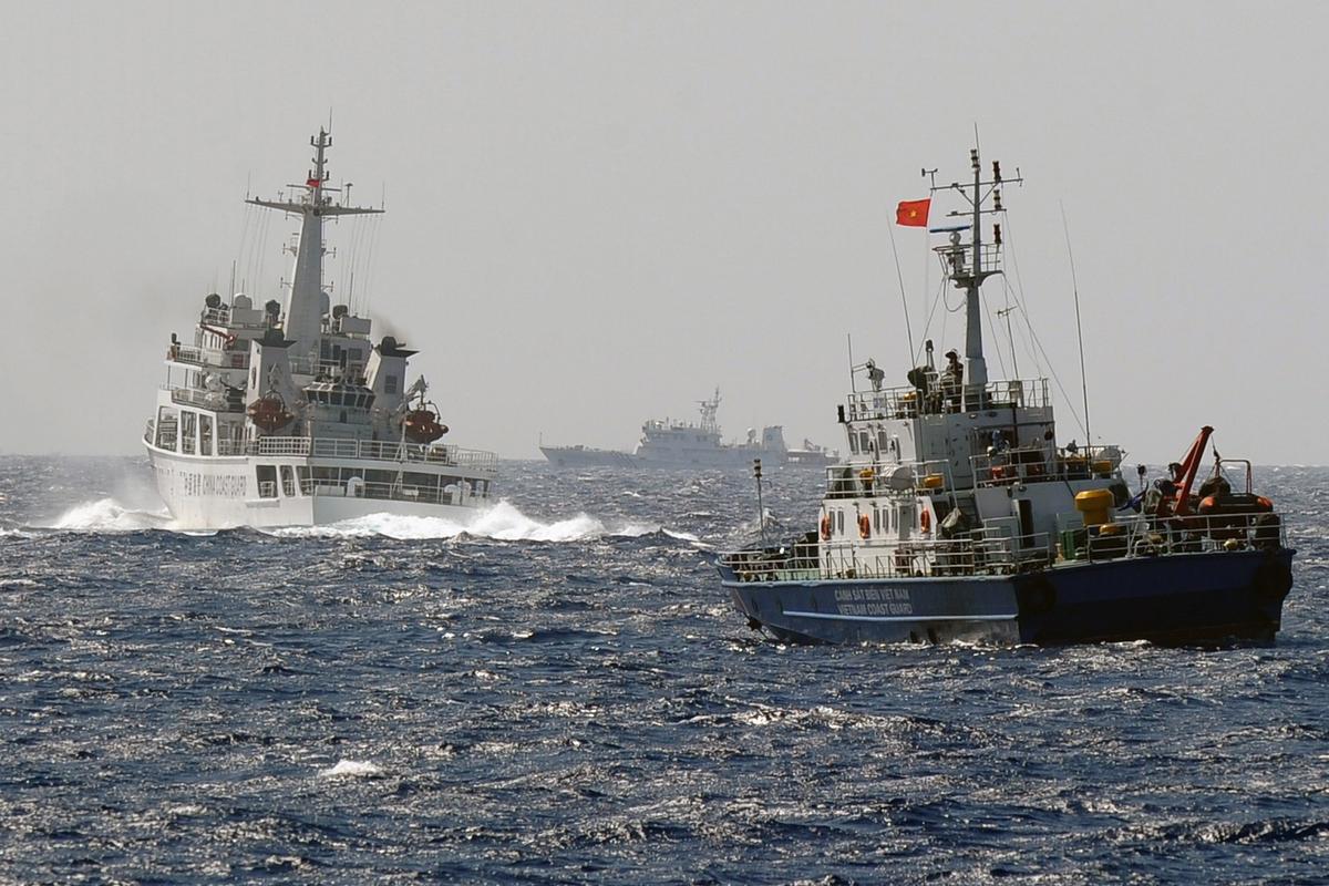 This picture taken from a Vietnam Coast Guard ship on May 14, 2014 shows a China Coast Guard ship (L) blocking the way of a Vietnam Coast Guard ship near to the site of a Chinese drilling oil rig (R, background) being installed at the disputed water in the South China Sea off Vietnam's central coast. (Hoang Dinh Nam/AFP/Getty Images)
