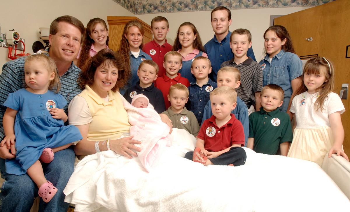 Michelle Duggar, left, is surrounded by her children and husband Jim Bob, third from right, after the birth of her 17th child in Rogers, Arkansas on Aug. 2, 2007. (AP Photo/ Beth Hall, File)