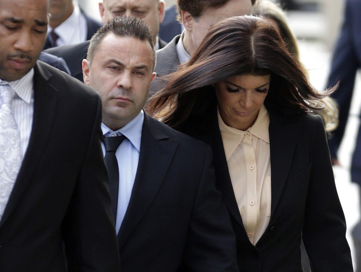 "The Real Housewives of New Jersey" stars Giuseppe "Joe" Giudice, center, and his wife, Teresa Giudice (R) of Montville Township, N.J., walk toward the Martin Luther King Jr. Courthouse before a court appearance, in Newark, N.J., on Oct. 2, 2014. (Julio Cortez/AP Photo)