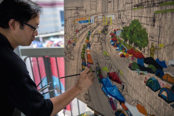 Hong Kong artist Perry Dino paints the "Umbrella Movement" pro-democracy protest area next to the central government offices, in Hong Kong on October 14, 2014. (Alex Ogle/AFP/Getty Images)