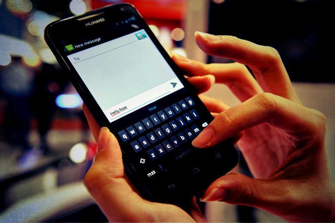 This photo, taken on June 21, 2012, shows a person using a mobile phone touchscreen keypad to write a text message in Singapore. (Roslin Rahman/AFP/GettyImages; effects added by Epoch Times)