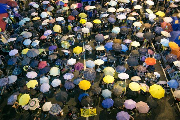 Pro-democracy protesters hold up umbrellas on Oct. 28, 2014 during a rally marking one month of the "Umbrella Revolution," coined when police shot tear gas at the protesters one month ago at the Central District in Hong Kong. (Benjamin Chasteen/The Epoch Times)