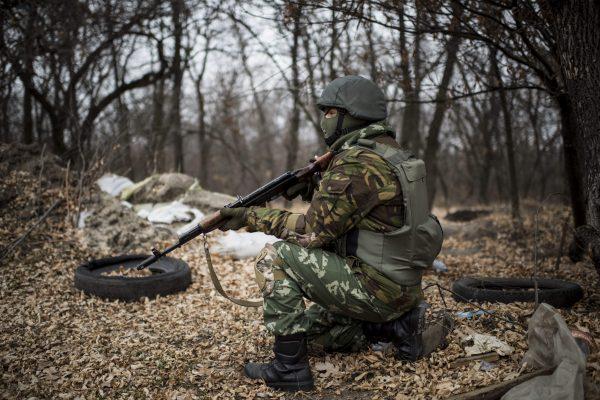 A Ukrainian serviceman gets ready to fire from his position next to a bridge over the river Siverskiy Donets, damaged by explosion during fighting between Pro-Russian rebels and Ukrainian government forces near Trehizbenka village, Luhansk region eastern Ukraine, in November 2014. (Evgeniy Maloletka/AP Photo)