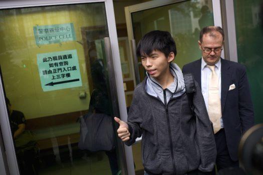Student leader Joshua Wong (L) gives a thumbs up as he exits a courthouse with his lawyer Michael Vidler (R) after Wong was released on bail in Hong Kong on Nov. 27, 2014. (Aaron Tam/AFP/Getty Images)