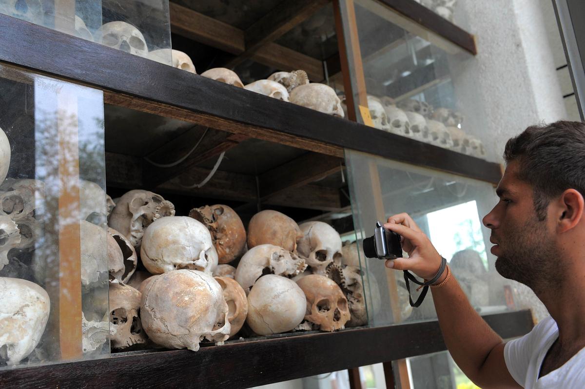 A tourist takes photos of skulls of Khmer Rouge victims displayed at the Choeung Ek killing fields memorial in Phnom Penh on May 4, 2011. The communist regime in Cambodia killed nearly a third of the country’s population. (Tang Chhin Sothy/AFP/Getty Images)