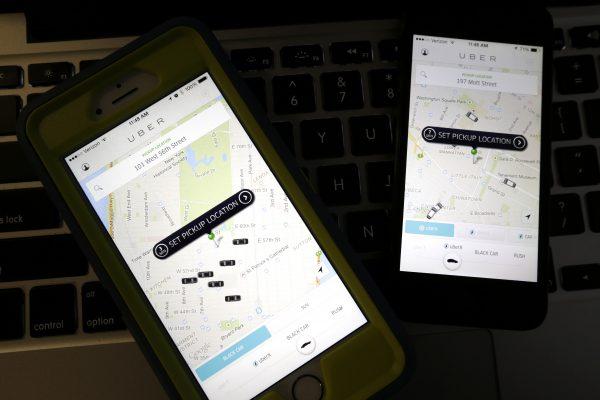 This photo taken in Newark, N.J., shows smartphones displaying Uber car availability in New York, on Nov. 21, 2014. (AP Photo/Julio Cortez)