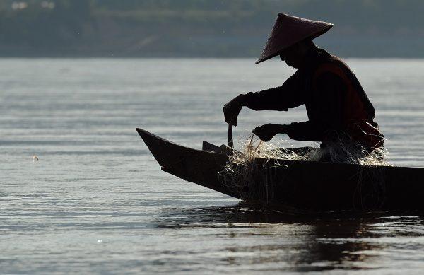 A fisherman pulls his net from the Mekong River in northern Thailand and bordering Laos, on May 29, 2013. (Christophe Archambault/AFP/Getty Images)