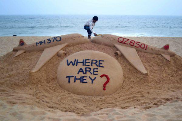 Indian sand artist Sudarsan Pattnaik gives the final touches to his sand sculpture portraying two missing aircraft, Air Asia QZ8501 and Malayasia Airlines MH370 on Golden Sea Beach at Puri, east of Bhubaneswar on Monday. (STRDEL/AFP/Getty Images)