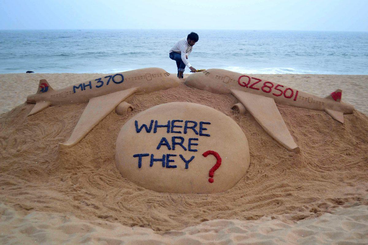 Indian sand artist Sudarsan Pattnaik gives the final touches to his sand sculpture portraying two missing aircraft, Air Asia QZ8501 and Malayasia Airlines MH370, on Golden Sea Beach at Puri, east of Bhubaneswar, India, on Dec. 29, 2014. (STRDEL/AFP/Getty Images)