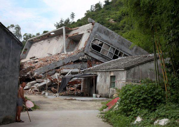 A man stands near the razed remains of a Catholic church in a village in Pingyang county of Wenzhou in eastern China's Zhejiang Province on July 16, 2014. (AP Photo/Didi Tang)