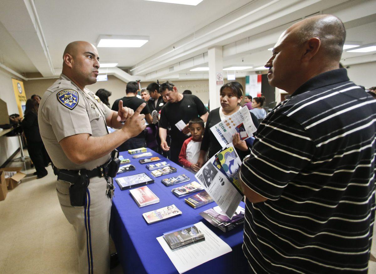 In this file photo, a California Highway Patrol officer explains to immigrants the process of getting a driver's license during an information session at the Mexican Consulate, in San Diego, Calif., on April 23, 2014. (AP Photo/Lenny Ignelzi)