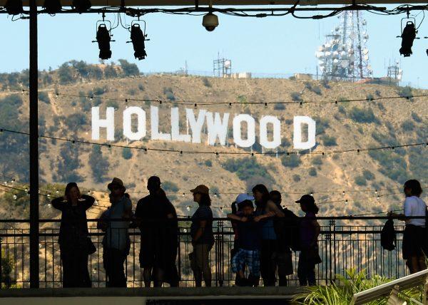 Tourists are silhouetted against the distorted Hollywood sign in Los Angeles on June 28, 2013. (Kevork Djansezian/Getty Images)