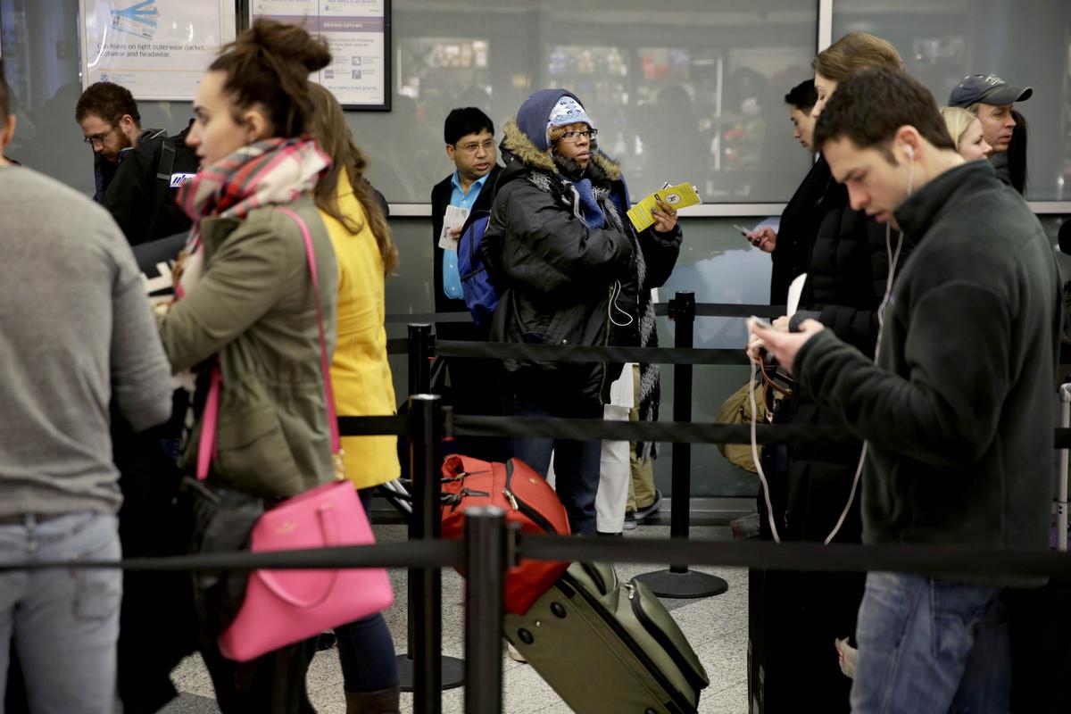 Air travelers wait to to board a flight at LaGuardia Airport in New York, Monday, Jan. 26, 2015. Airlines cancelled thousands of flights into and out of East Coast airports as a major snowstorm packing up to three feet of snow barrels down on the region. (AP Photo/Seth Wenig)