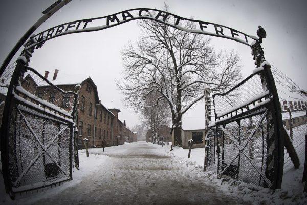 A woman walks through snow near the entrance to the former Nazi concentration camp Auschwitz-Birkenau with the lettering 'Arbeit macht frei' ('Work makes you free') in Oswiecim, Poland, on Jan. 25, 2015. (Joel Saget/AFP/Getty Images)
