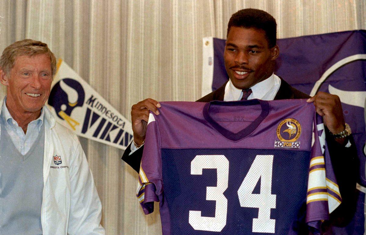 Former Dallas Cowboys running back Herschel Walker displays his new jersey after he was traded to the Minnesota Vikings for a number of players and draft choices on Oct. 12, 1989. (Jim Mone/AP Photo)