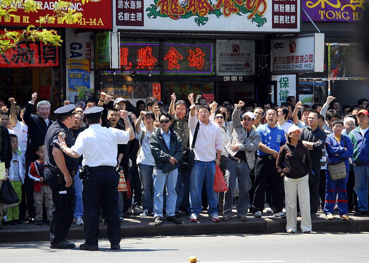 Police monitor pro-CCP members who yell threats and insults at Falun Gong practitioners who are across the street in Flushing, New York, in June 2008. (The Epoch Times)