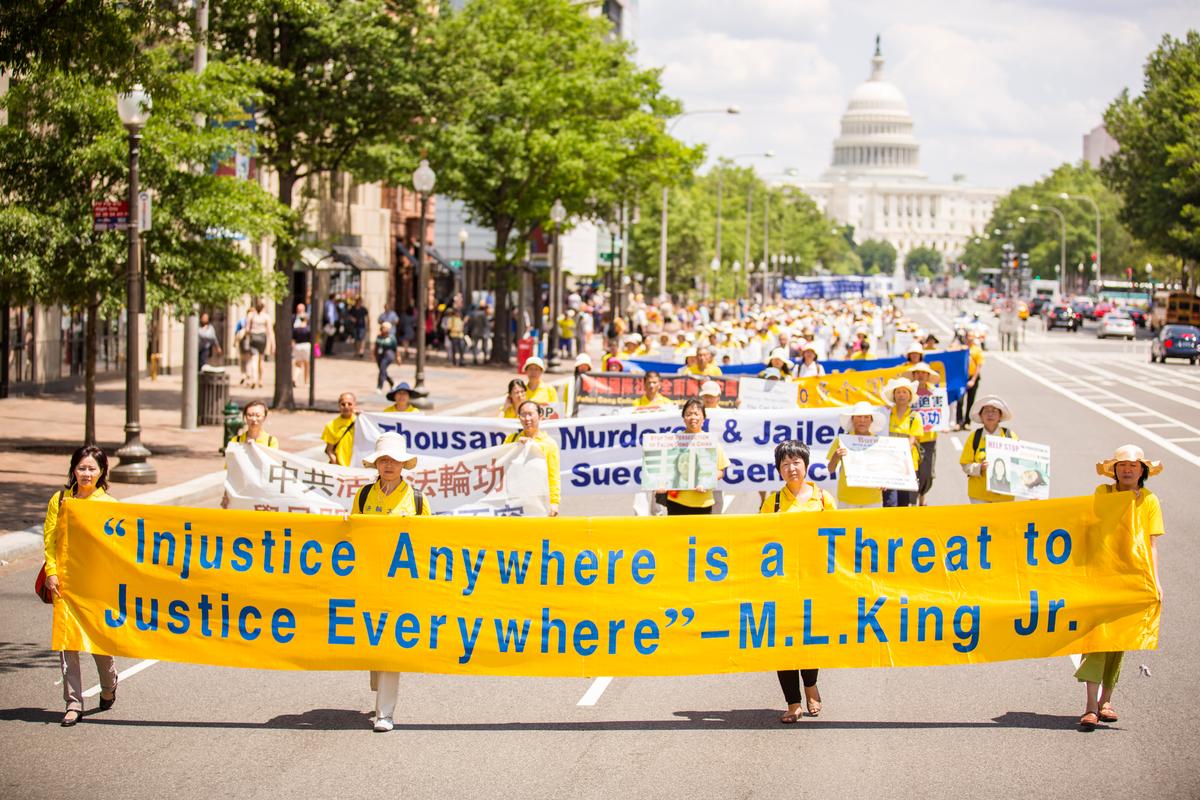Falun Gong practitioners march in a parade calling for an end to the persecution in China, as the U.S. Capitol building is in the background, in Washington, D.C., on July 17, 2014. (Edward Dye/Epoch Times)