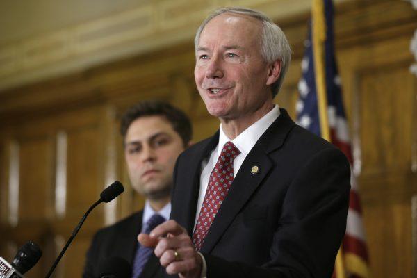 Arkansas Gov. Asa Hutchinson answers reporters' questions as Sen. Jonathan Dismang, R-Beebe, background, listens at the state Capitol in Little Rock, Ark., on April 1, 2015. (Danny Johnston/Photo via AP)