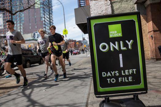 A group of men run past an H&R Block on April 15, 2015 in New York City. Today is the deadline for filing federal income taxes. (Andrew Burton/Getty Images)