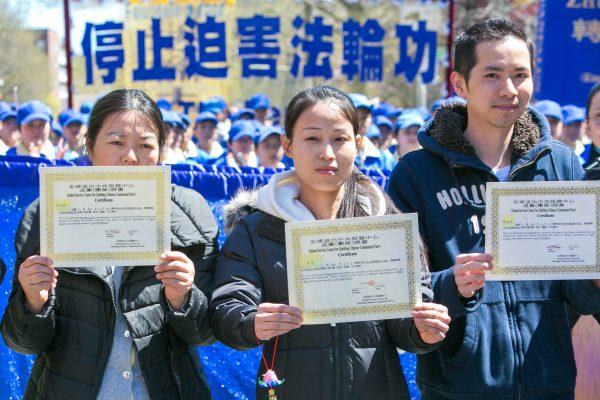 People from mainland China hold certificates they received after quitting the Chinese Communist Party during a parade in Flushing, New York, on April 25, 2015. (Benjamin Chasteen/Epoch Times)