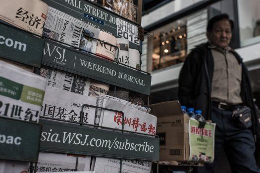A man walks past a newspaper kiosk in Hong Kong on Jan. 12, 2015. (Philippe Lopez/AFP/Getty Images)