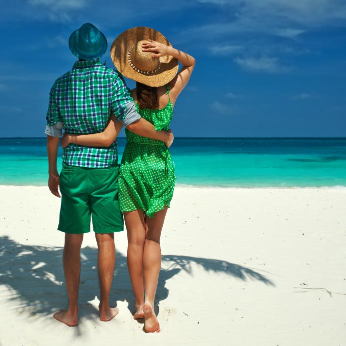 Couple in green on a tropical beach at Maldives. (haveseen/iStock)