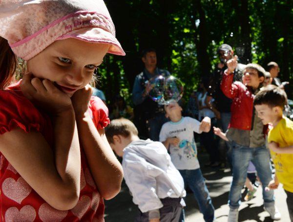 A girl stands as children play in Kyiv, Ukraine, on May 28, 2013. (Sergei Supinsky/AFP/Getty Images)