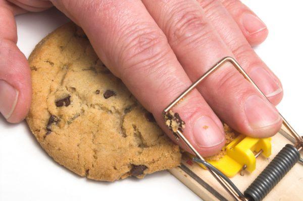 Fingers and a cookie in a cheese trap. (robeo/iStock)
