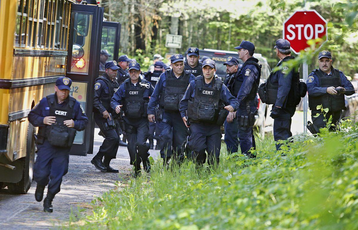 New York State Department of Corrections and Community Supervision officers rush off a school bus in Mountain View, N.Y., on June 23, 2015, while searching for two prison escapees from Clinton Correctional Facility. (Jason Hunter/The Watertown Daily Times via AP)