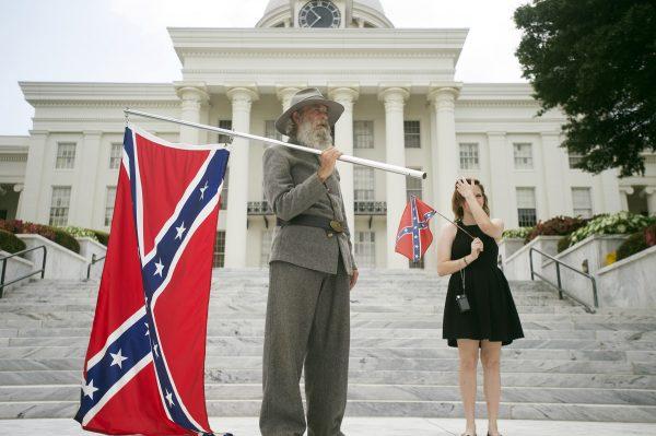 Dan Williams, 65, of Ashville, Ala., holds a Confederate flag while standing with his daughter Bonnie-Blue Williams, 15, in front of the Alabama State Capitol building, on June 27, 2015. (Albert Cesare/The Montgomery Advertiser/AP)