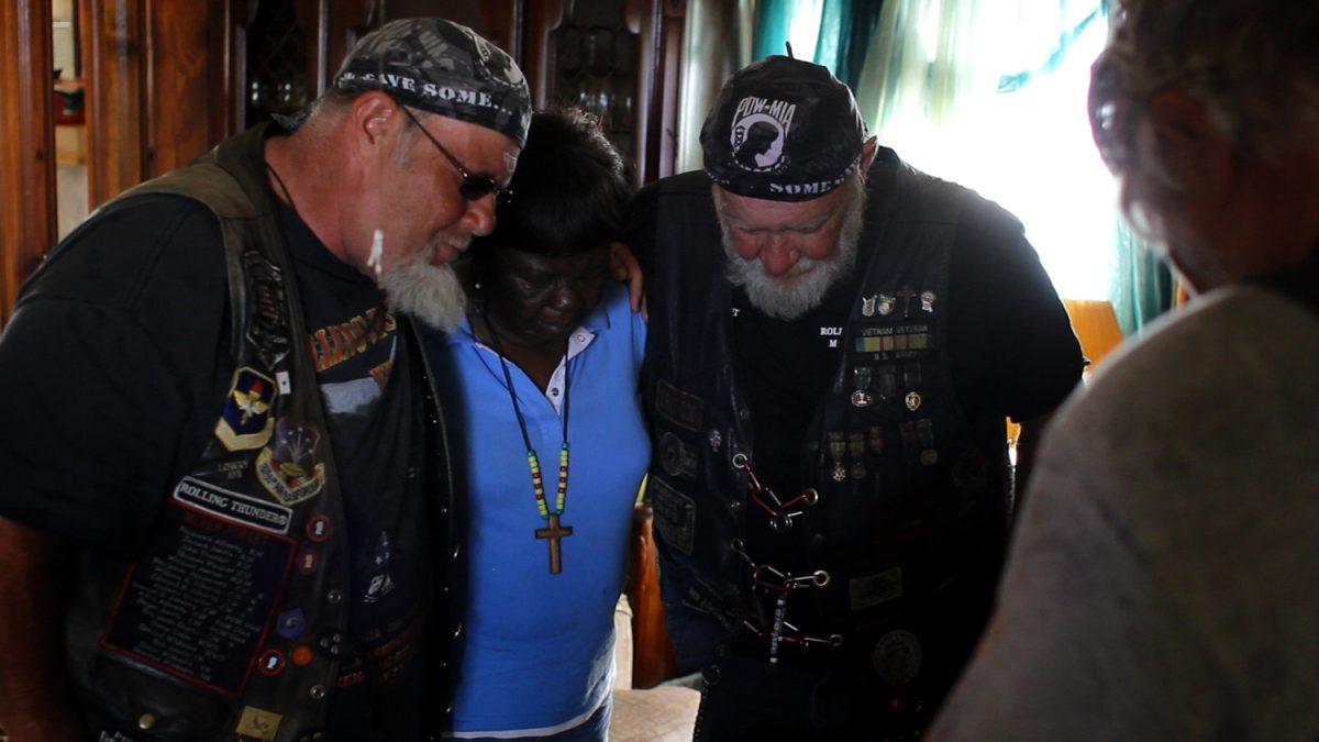 Ron "Stray Dog" Hall (center, R) and fellow veterans in prayer with Annie Washington (center, L), who lost her daughter in Afghanistan, in the documentary film "Stray Dog." (Still Rolling Productions)