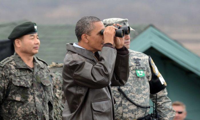 U.S. President Barack Obama uses binoculars to look at North Korea from the Observation Post Ouellette in the Demilitarized Zone, which separates the two Koreas in the inter-Korean truce village of Panmunjom, South Korea, on March 25, 2012. (Yonhap News via Getty Images)