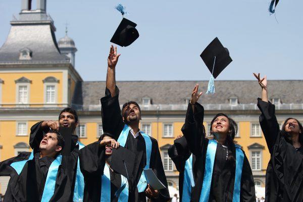 Students at a graduation ceremony. Many graduate with unpayable, crippling student debt. (Andreas Rentz/Getty Images)