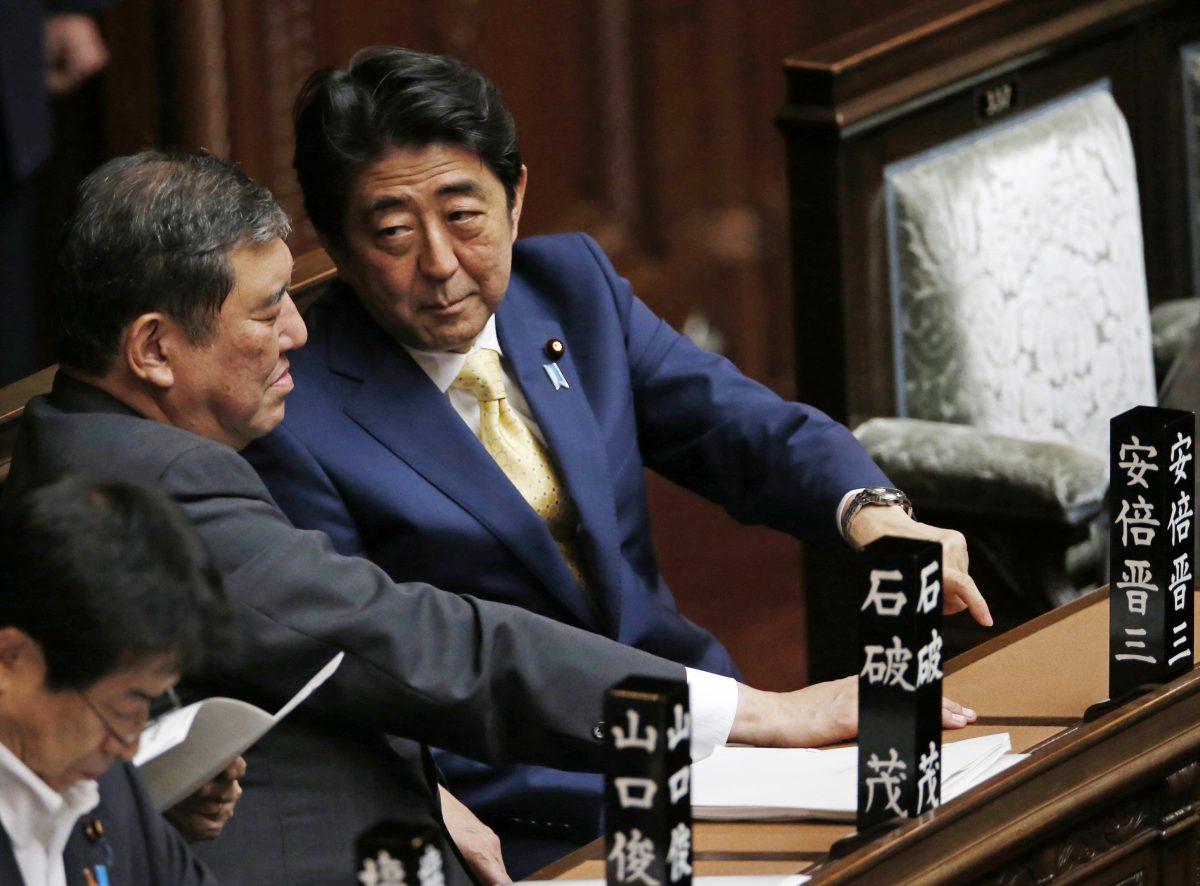 Japanese Prime Minister Shinzo Abe, right, talks to Shigeru Ishiba, the minister for Vitalizing Local Economy in Japan, during a plenary session at the lower house in Tokyo on July 16, 2015. (Shuji Kajiyama/AP Photo)
